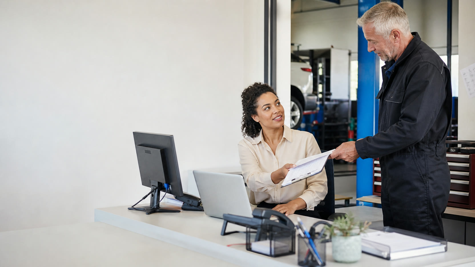 An office manager receiving completed job information from a field engineer.