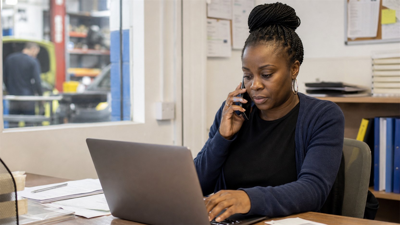 An office coordinator capturing a new customer enquiry in a small trade business office.